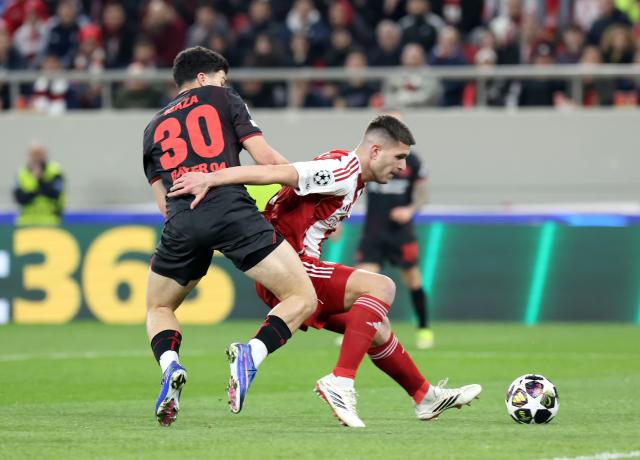 18 February 2026, Piräus: Olympiacos' Lorenzo Pirola (R) and Leverkusen's Ibrahim Maza battle for the ball during the UEFA Champions League soccer match between Olympiacos F.C. and Bayer 04 Leverkusen at Georgios Karaiskakis Stadium. Photo: Yorgos Karahalis/dpa