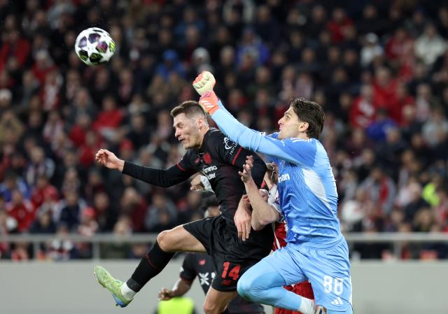 18 February 2026, Piräus: Olympiacos goalkeeper Konstantinos Tzolakis (R) and Leverkusen's Patrik Schick battle for the ball during the UEFA Champions League soccer match between Olympiacos F.C. and Bayer 04 Leverkusen at Georgios Karaiskakis Stadium. Photo: Yorgos Karahalis/dpa