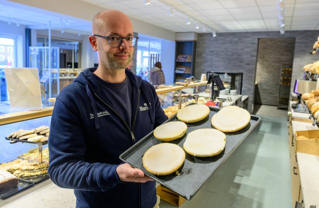 18 February 2026, Lower Saxony, Lueneburg: Jannik Harms, Managing Director of "De Heidbaecker GmbH", holds a tray of "Groenlaender" (Greenlander) cookies. The German bakery chain has renamed its beloved cookie in solidarity with Greenland, changing the name of Amerikaners to Greenlanders. Photo: Philipp Schulze/dpa