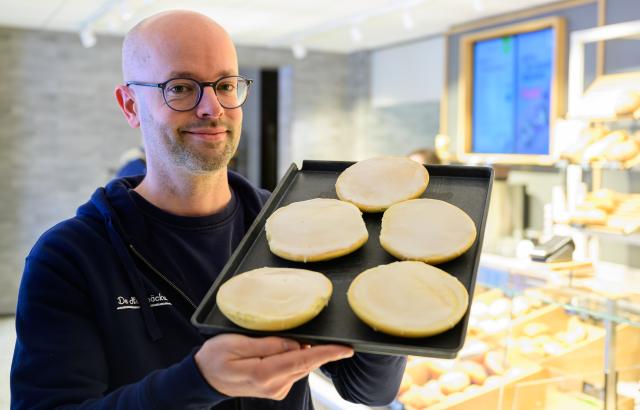 18 February 2026, Lower Saxony, Lueneburg: Jannik Harms, Managing Director of "De Heidbaecker GmbH", holds a tray of "Groenlaender" (Greenlander) cookies. The German bakery chain has renamed its beloved cookie in solidarity with Greenland, changing the name of Amerikaners to Greenlanders. Photo: Philipp Schulze/dpa
