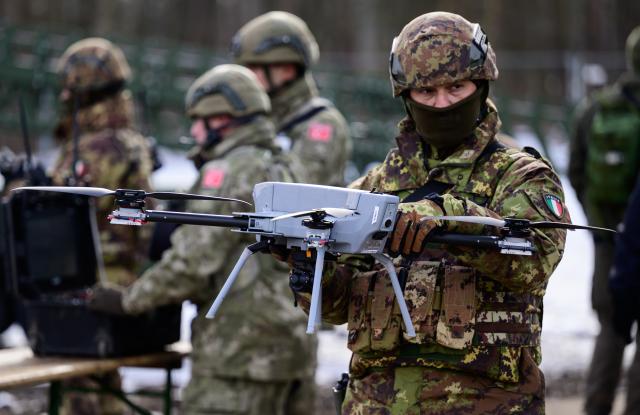 19 February 2026, Lower Saxony, Bergen: An Italian soldier shows off a drone during an exhibition as part of a NATO exercise in Bergen. NATO's largest multinational exercise of the year began on January 15. According to the Bundeswehr, Germany is both the "hub" and host nation in the first quarter. Photo: Philipp Schulze/dpa