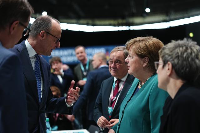 20 February 2026, Baden-Württemberg, Stuttgart: German Chancellor and CDU party chairman Friedrich Merz welcomes former Chancellor Angela Merkel at the CDU party conference. The party is re-electing its leadership bodies, with Merz running unopposed for a third term as chairman. Photo: Kay Nietfeld/dpa pool/dpa