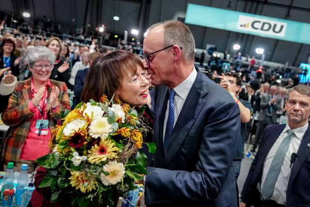 20 February 2026, Baden-Wuerttemberg, Stuttgart: German Chancellor Friedrich Merz (R) presents his wife Charlotte with a bouquet of flowers after his election as federal chairman at the Christian Democratic Union of Germany (CDU) federal party conference. Photo: Kay Nietfeld/dpa