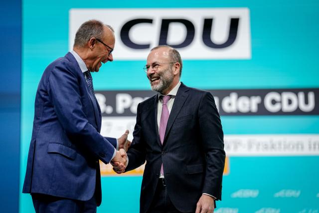 21 February 2026, Baden-Württemberg, Stuttgart: German Chancellor Friedrich Merz (l, CDU), CDU Federal Chairman, and Manfred Weber, Chairman of the EPP, take part in the CDU Federal Party Conference. After the board elections, the second day of the party conference will focus on content. Among other things, motions on part-time work, restrictions on social media use for children and pension reform will be discussed. Photo: Kay Nietfeld/dpa