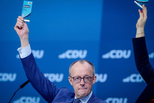 21 February 2026, Baden-Württemberg, Stuttgart: German Chancellor Friedrich Merz (CDU), CDU Federal Chairman, raises his voting card at the CDU Federal Party Conference. After the board elections, the second day of the party conference will focus on content. Among other things, motions on part-time work, restrictions on social media use for children and pension reform will be discussed. Photo: Kay Nietfeld/dpa