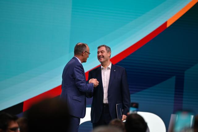 21 February 2026, Baden-Württemberg, Stuttgart: German Chancellor Friedrich Merz (L) receives Markus Soeder, CSU Chairman and Minister President of Bavaria, at the CDU federal party conference. After the board elections, the second day of the party conference is all about content. Among other things, motions on part-time work, restricting social media use for children and pension reform will be discussed. Photo: Kay Nietfeld/dpa