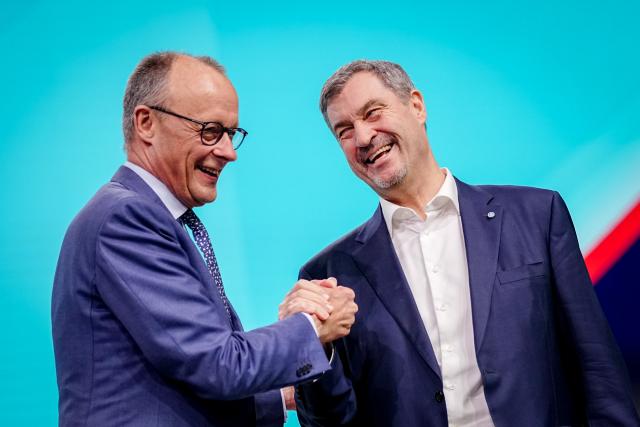 21 February 2026, Baden-Württemberg, Stuttgart: German Chancellor Friedrich Merz (L) receives Markus Soeder, CSU Chairman and Minister President of Bavaria, at the CDU federal party conference. After the board elections, the second day of the party conference is all about content. Among other things, motions on part-time work, restricting social media use for children and pension reform will be discussed. Photo: Kay Nietfeld/dpa
