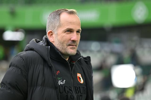 21 February 2026, Lower Saxony, Wolfsburg: Augsburg coach Manuel Baum inspects the pitch prior to the start of the German Bundesliga soccer match between VfL Wolfsburg and FC Augsburg at Volkswagen Arena. Photo: Swen Pförtner/dpa - WICHTIGER HINWEIS: Gemäß den Vorgaben der DFL Deutsche Fußball Liga bzw. des DFB Deutscher Fußball-Bund ist es untersagt, in dem Stadion und/oder vom Spiel angefertigte Fotoaufnahmen in Form von Sequenzbildern und/oder videoähnlichen Fotostrecken zu verwerten bzw. verwerten zu lassen.