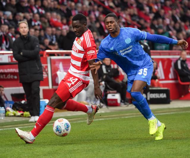21 February 2026, Berlin: Union Berlin's Stanley Nsoki (L) and Bayer Leverkusen's Christian Kofane battle for the ball during the German Bundesliga soccer match between 1. FC Union Berlin and Bayer Leverkusen at An der Alten Försterei. Photo: Soeren Stache/dpa - WICHTIGER HINWEIS: Gemäß den Vorgaben der DFL Deutsche Fußball Liga bzw. des DFB Deutscher Fußball-Bund ist es untersagt, in dem Stadion und/oder vom Spiel angefertigte Fotoaufnahmen in Form von Sequenzbildern und/oder videoähnlichen Fotostrecken zu verwerten bzw. verwerten zu lassen.