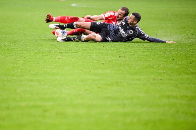 21 February 2026, Bavaria, Munich: Bayern Munich's Harry Kane (L) and Eintracht Frankfurt's Ellyes Skhiri battle for the ball during the German Bundesliga soccer match between Bayern Munich and Eintracht Frankfurt at Allianz Arena. Photo: Harry Langer/dpa - WICHTIGER HINWEIS: Gemäß den Vorgaben der DFL Deutsche Fußball Liga bzw. des DFB Deutscher Fußball-Bund ist es untersagt, in dem Stadion und/oder vom Spiel angefertigte Fotoaufnahmen in Form von Sequenzbildern und/oder videoähnlichen Fotostrecken zu verwerten bzw. verwerten zu lassen.