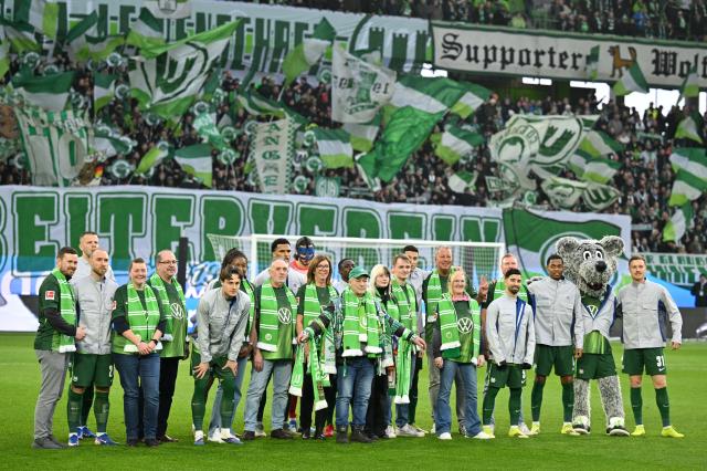 21 February 2026, Lower Saxony, Wolfsburg: Members and players of VfL Wolfsburg pose for a team photo in front of the fans before the German Bundesliga soccer match between VfL Wolfsburg and FC Augsburg at Volkswagen Arena. Photo: Swen Pförtner/dpa - WICHTIGER HINWEIS: Gemäß den Vorgaben der DFL Deutsche Fußball Liga bzw. des DFB Deutscher Fußball-Bund ist es untersagt, in dem Stadion und/oder vom Spiel angefertigte Fotoaufnahmen in Form von Sequenzbildern und/oder videoähnlichen Fotostrecken zu verwerten bzw. verwerten zu lassen.