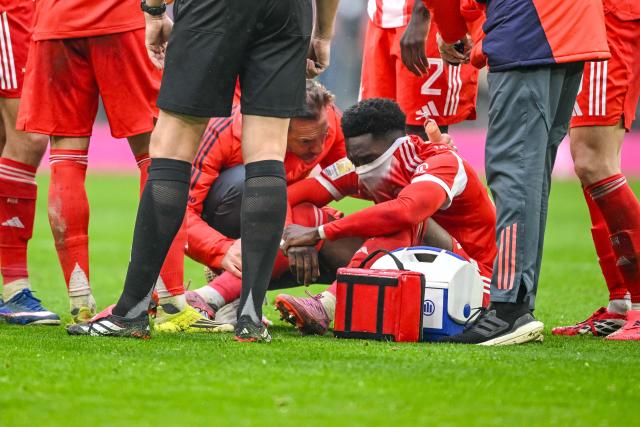 21 February 2026, Bavaria, Munich: Bayern Munich's Alphonso Davies (R) sits injured on the ground during the German Bundesliga soccer match between Bayern Munich and Eintracht Frankfurt at Allianz Arena. Photo: Harry Langer/dpa - WICHTIGER HINWEIS: Gemäß den Vorgaben der DFL Deutsche Fußball Liga bzw. des DFB Deutscher Fußball-Bund ist es untersagt, in dem Stadion und/oder vom Spiel angefertigte Fotoaufnahmen in Form von Sequenzbildern und/oder videoähnlichen Fotostrecken zu verwerten bzw. verwerten zu lassen.
