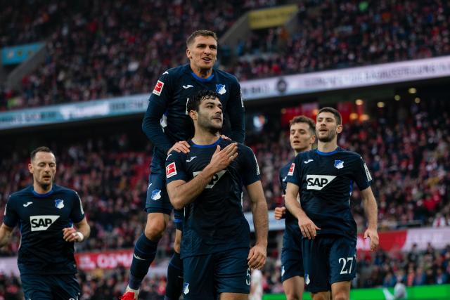 21 February 2026, North Rhine-Westphalia, Cologne: Hoffenheim's scorers Ozan Kabak (C) celebrate scoring his side's first goal with teammate Andrej Kramaric during the German Bundesliga soccer match between 1. FC Cologne and TSG 1899 Hoffenheim at RheinEnergieStadion. Photo: Marius Becker/dpa - WICHTIGER HINWEIS: Gemäß den Vorgaben der DFL Deutsche Fußball Liga bzw. des DFB Deutscher Fußball-Bund ist es untersagt, in dem Stadion und/oder vom Spiel angefertigte Fotoaufnahmen in Form von Sequenzbildern und/oder videoähnlichen Fotostrecken zu verwerten bzw. verwerten zu lassen.