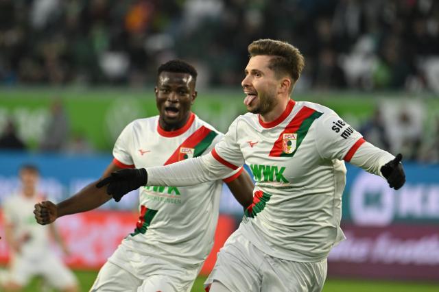 21 February 2026, Lower Saxony, Wolfsburg: Augsburg's Elvis Rexhbecaj celebrates scoring his side's third goal during the German Bundesliga soccer match between VfL Wolfsburg and FC Augsburg at Volkswagen Arena. Photo: Swen Pförtner/dpa - WICHTIGER HINWEIS: Gemäß den Vorgaben der DFL Deutsche Fußball Liga bzw. des DFB Deutscher Fußball-Bund ist es untersagt, in dem Stadion und/oder vom Spiel angefertigte Fotoaufnahmen in Form von Sequenzbildern und/oder videoähnlichen Fotostrecken zu verwerten bzw. verwerten zu lassen.