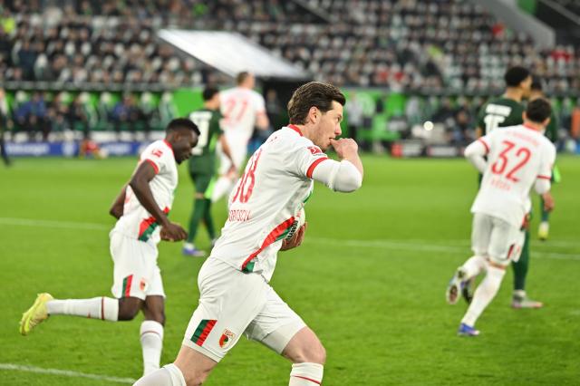 21 February 2026, Lower Saxony, Wolfsburg: Augsburg's Michael Gregoritsch celebrates scoring his side's second goal during the German Bundesliga soccer match between VfL Wolfsburg and FC Augsburg at Volkswagen Arena. Photo: Swen Pförtner/dpa - WICHTIGER HINWEIS: Gemäß den Vorgaben der DFL Deutsche Fußball Liga bzw. des DFB Deutscher Fußball-Bund ist es untersagt, in dem Stadion und/oder vom Spiel angefertigte Fotoaufnahmen in Form von Sequenzbildern und/oder videoähnlichen Fotostrecken zu verwerten bzw. verwerten zu lassen.