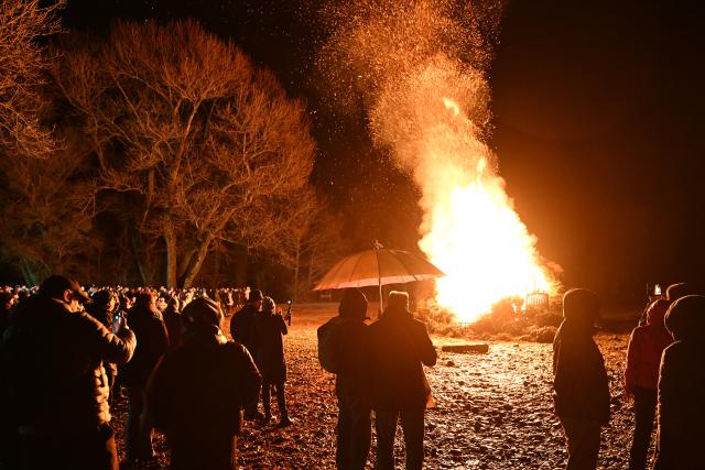 21 February 2026, Baden-Wuerttemberg, Langenargen Am Bodensee: Visitors watch the bonfire that was lit in the evening on the shore of Lake Constance at Malereck. Photo: Felix Kästle/dpa