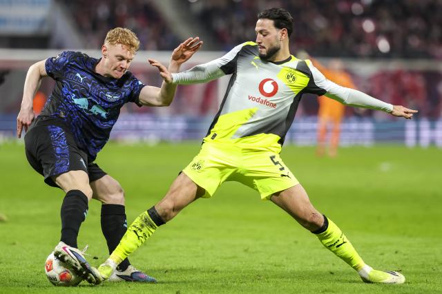 21 February 2026, Saxony, Leipzig: Leipzig's Nicolas Seiwald (L) and Borussia Dortmund's Ramy Bensebaini battle for the ball during the German Bundesliga soccer match between RB Leipzig and Borussia Dortmund at Red Bull Arena. Photo: Jan Woitas/dpa - WICHTIGER HINWEIS: Gemäß den Vorgaben der DFL Deutsche Fußball Liga bzw. des DFB Deutscher Fußball-Bund ist es untersagt, in dem Stadion und/oder vom Spiel angefertigte Fotoaufnahmen in Form von Sequenzbildern und/oder videoähnlichen Fotostrecken zu verwerten bzw. verwerten zu lassen.