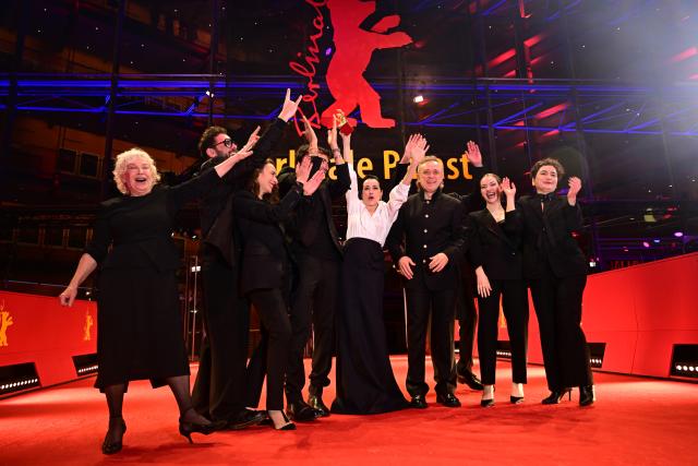 21 February 2026, Berlin: The team behind the film "Yellow Letters" shows off their award, the Golden Bear for Best Film, after the award ceremony at the closing gala of the 76th Berlin International Film Festival. Photo: Sebastian Christoph Gollnow/dpa