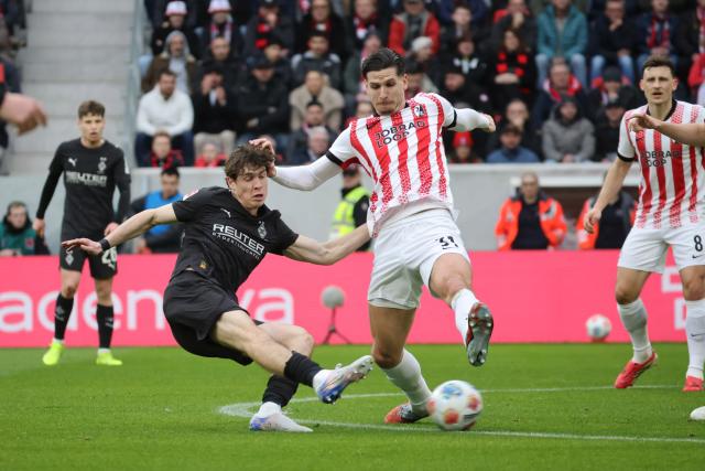 22 February 2026, Baden-Wuerttemberg, Freiburg im Breisgau: Borussia Moenchengladbach's Philipp Sander (L) and Freiburg's Igor Matanovic battle for the ball during the German Bundesliga soccer match between SC Freiburg and Borussia Moenchengladbach at Europa-Park Stadium. Photo: Philipp von Ditfurth/dpa - WICHTIGER HINWEIS: Gemäß den Vorgaben der DFL Deutsche Fußball Liga bzw. des DFB Deutscher Fußball-Bund ist es untersagt, in dem Stadion und/oder vom Spiel angefertigte Fotoaufnahmen in Form von Sequenzbildern und/oder videoähnlichen Fotostrecken zu verwerten bzw. verwerten zu lassen.