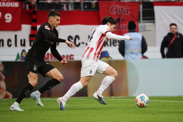 22 February 2026, Baden-Wuerttemberg, Freiburg im Breisgau: Borussia Moenchengladbach's Yannik Engelhardt (L) and Freiburg's Yuito Suzuki battle for the ball during the German Bundesliga soccer match between SC Freiburg and Borussia Moenchengladbach at Europa-Park Stadium. Photo: Philipp von Ditfurth/dpa - WICHTIGER HINWEIS: Gemäß den Vorgaben der DFL Deutsche Fußball Liga bzw. des DFB Deutscher Fußball-Bund ist es untersagt, in dem Stadion und/oder vom Spiel angefertigte Fotoaufnahmen in Form von Sequenzbildern und/oder videoähnlichen Fotostrecken zu verwerten bzw. verwerten zu lassen.