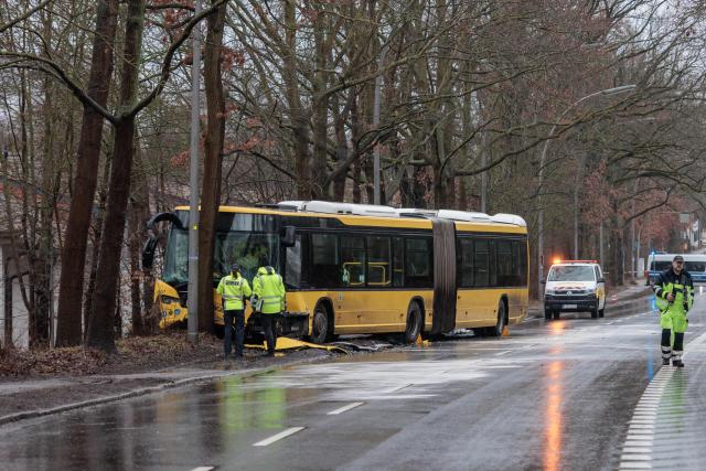22 February 2026, Berlin: Police officers stand in front of a damaged bus at the scene of an accident. Twelve people were injured in the accident. Photo: Carsten Koall/dpa