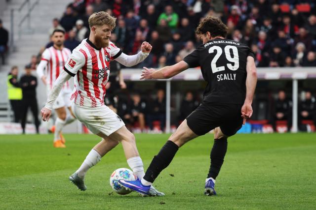 22 February 2026, Baden-Wuerttemberg, Freiburg im Breisgau: Freiburg's Jan-Niklas Beste (L) and Borussia Moenchengladbach's Joe Scally battle for the ball during the German Bundesliga soccer match between SC Freiburg and Borussia Moenchengladbach at Europa-Park Stadium. Photo: Philipp von Ditfurth/dpa - WICHTIGER HINWEIS: Gemäß den Vorgaben der DFL Deutsche Fußball Liga bzw. des DFB Deutscher Fußball-Bund ist es untersagt, in dem Stadion und/oder vom Spiel angefertigte Fotoaufnahmen in Form von Sequenzbildern und/oder videoähnlichen Fotostrecken zu verwerten bzw. verwerten zu lassen.