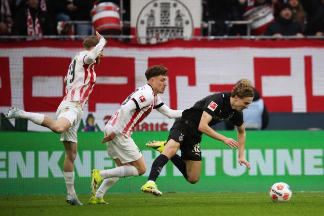 22 February 2026, Baden-Wuerttemberg, Freiburg im Breisgau: Freiburg's Jan-Niklas Beste (L) and Freiburg's Philipp Treu (C) and Borussia Moenchengladbach's Hugo Bolin battle for the ball during the German Bundesliga soccer match between SC Freiburg and Borussia Moenchengladbach at Europa-Park Stadium. Photo: Philipp von Ditfurth/dpa - WICHTIGER HINWEIS: Gemäß den Vorgaben der DFL Deutsche Fußball Liga bzw. des DFB Deutscher Fußball-Bund ist es untersagt, in dem Stadion und/oder vom Spiel angefertigte Fotoaufnahmen in Form von Sequenzbildern und/oder videoähnlichen Fotostrecken zu verwerten bzw. verwerten zu lassen.