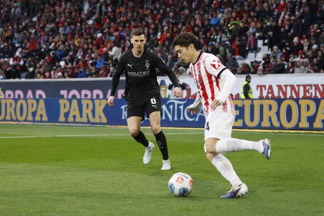22 February 2026, Baden-Wuerttemberg, Freiburg im Breisgau: Borussia Moenchengladbach's Yannik Engelhardt (L) and Freiburg's Yuito Suzuki battle for the ball during the German Bundesliga soccer match between SC Freiburg and Borussia Moenchengladbach at Europa-Park Stadium. Photo: Philipp von Ditfurth/dpa - WICHTIGER HINWEIS: Gemäß den Vorgaben der DFL Deutsche Fußball Liga bzw. des DFB Deutscher Fußball-Bund ist es untersagt, in dem Stadion und/oder vom Spiel angefertigte Fotoaufnahmen in Form von Sequenzbildern und/oder videoähnlichen Fotostrecken zu verwerten bzw. verwerten zu lassen.