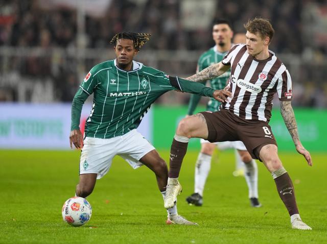 22 February 2026, Hamburg: FC St. Pauli's Eric Smith (R) and Werder Bremen's Samuel Mbangula battle for the ball during the German Bundesliga soccer match between FC St. Pauli and Werder Bremen at Millerntor Stadium. Photo: Marcus Brandt/dpa - WICHTIGER HINWEIS: Gemäß den Vorgaben der DFL Deutsche Fußball Liga bzw. des DFB Deutscher Fußball-Bund ist es untersagt, in dem Stadion und/oder vom Spiel angefertigte Fotoaufnahmen in Form von Sequenzbildern und/oder videoähnlichen Fotostrecken zu verwerten bzw. verwerten zu lassen.