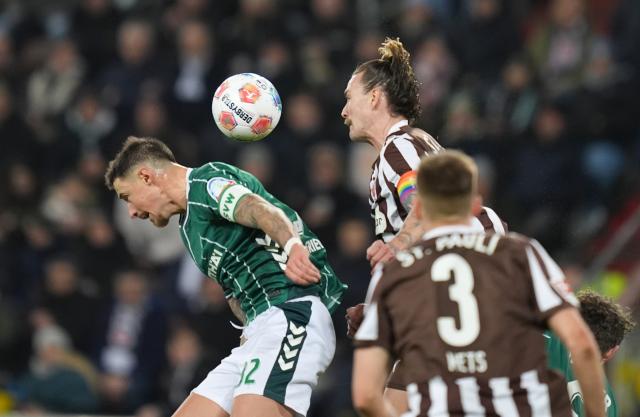22 February 2026, Hamburg: Werder Bremen's Marco Friedl (L) and FC St. Pauli's Jackson Irvine battle for the ball during the German Bundesliga soccer match between FC St. Pauli and Werder Bremen at Millerntor Stadium. Photo: Marcus Brandt/dpa - WICHTIGER HINWEIS: Gemäß den Vorgaben der DFL Deutsche Fußball Liga bzw. des DFB Deutscher Fußball-Bund ist es untersagt, in dem Stadion und/oder vom Spiel angefertigte Fotoaufnahmen in Form von Sequenzbildern und/oder videoähnlichen Fotostrecken zu verwerten bzw. verwerten zu lassen.