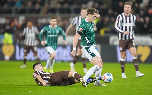 22 February 2026, Hamburg: FC St. Pauli's Arkadiusz Pyrka (L) and Werder Bremen's Jens Stage battle for the ball during the German Bundesliga soccer match between FC St. Pauli and Werder Bremen at Millerntor Stadium. Photo: Marcus Brandt/dpa - WICHTIGER HINWEIS: Gemäß den Vorgaben der DFL Deutsche Fußball Liga bzw. des DFB Deutscher Fußball-Bund ist es untersagt, in dem Stadion und/oder vom Spiel angefertigte Fotoaufnahmen in Form von Sequenzbildern und/oder videoähnlichen Fotostrecken zu verwerten bzw. verwerten zu lassen.