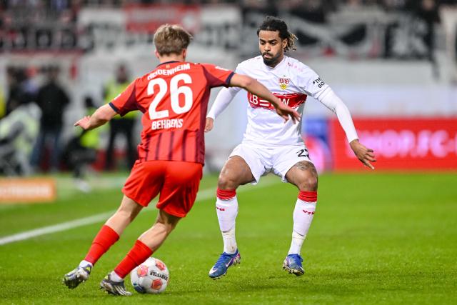 22 February 2026, Baden-Wuerttemberg, Heidenheim: Heidenheim's Hennes Behrens (L) and Stuttgart's Lorenz Assignon battle for the ball during the German Bundesliga soccer match between 1. FC Heidenheim and VfB Stuttgart at the Voith Arena. Photo: Harry Langer/dpa - WICHTIGER HINWEIS: Gemäß den Vorgaben der DFL Deutsche Fußball Liga bzw. des DFB Deutscher Fußball-Bund ist es untersagt, in dem Stadion und/oder vom Spiel angefertigte Fotoaufnahmen in Form von Sequenzbildern und/oder videoähnlichen Fotostrecken zu verwerten bzw. verwerten zu lassen.