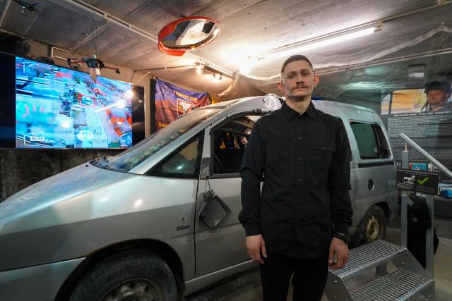 23 February 2026, Berlin: Oleg Degusarov, survivor of the Russian drone attack on the civilian Fiat Scudo, stands in front of the destroyed car during the press conference for the opening of the Ukraine Museum in the Berlin Story Bunker. The museum claims to be the first of its kind in the world and displays the largest collection of war artifacts from the country outside of Ukraine. Photo: Soeren Stache/dpa