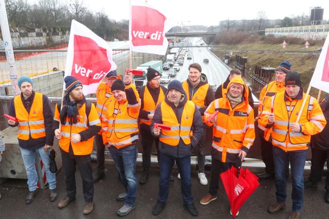 23 February 2026, Hamburg: Participants stand on a bridge near the Elbe tunnel over the A7 highway southbound during a warning strike. Drivers in the Hamburg area are facing a difficult start to the week. Traffic disruptions are expected on the A7 due to a warning strike at the Elbe Tunnel operations center starting Monday morning. Photo: Bodo Marks/dpa