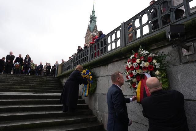 24 February 2026, Hamburg: Andy Grote (2nd R), Senator for the Interior and Sport, Iryna Tybinka (L), Consul General of Ukraine, and Frank Schmitt (R), Vice President of the Hamburg Parliament, commemorate the fourth anniversary of the victims of the Russian invasion of Ukraine with a wreath-laying ceremony in front of the "Memorial to the Fallen of Both World Wars". Photo: Marcus Brandt/dpa