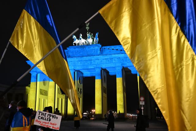24 February 2026, Berlin: The Brandenburg Gate is illuminated in the colors of the Ukraine flag as participants gather to mark the fourth anniversary of the outbreak of the war in Ukraine. Photo: Markus Lenhardt/dpa