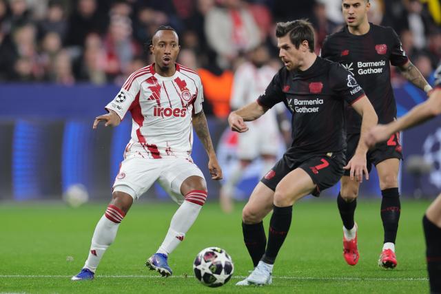 24 February 2026, North Rhine-Westphalia, Leverkusen: Olympiacos Piraeus' Gelson Martins (L) and Bayer Leverkusen's Jonas Hofmann battle for the ball during the UEFA Champions League knockout phase play offs, second leg soccer match between Bayer Leverkusen and Olympiacos Piraeus at BayArena. Photo: Rolf Vennenbernd/dpa