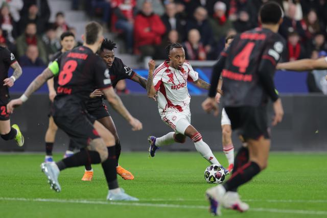 24 February 2026, North Rhine-Westphalia, Leverkusen: Olympiacos Piraeus' Gelson Martins and Bayer Leverkusen's Edmond Tapsoba (2nd L) battle for the ball during the UEFA Champions League knockout phase play offs, second leg soccer match between Bayer Leverkusen and Olympiacos Piraeus at BayArena. Photo: Rolf Vennenbernd/dpa