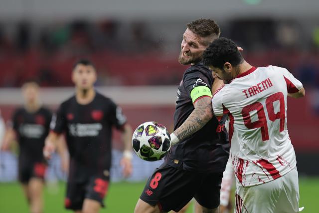 24 February 2026, North Rhine-Westphalia, Leverkusen: Olympiacos Piraeus' Mehdi Taremi (R) and Bayer Leverkusen's Robert Andrich battle for the ball during the UEFA Champions League knockout phase play offs, second leg soccer match between Bayer Leverkusen and Olympiacos Piraeus at BayArena. Photo: Rolf Vennenbernd/dpa