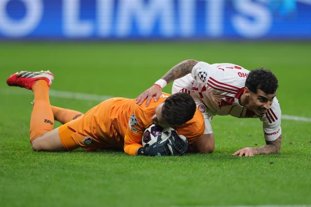 24 February 2026, North Rhine-Westphalia, Leverkusen: Bayer Leverkusen goalkeeper Janis Blaswich and Olympiacos Piraeus' Chiquinho battle for the ball during the UEFA Champions League knockout phase play offs, second leg soccer match between Bayer Leverkusen and Olympiacos Piraeus at BayArena. Photo: Rolf Vennenbernd/dpa
