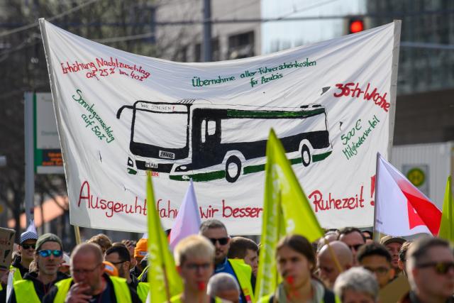 26 February 2026, Saxony-Anhalt, Magdeburg: Strikers hold a placard reading  "We drive better when rested", "35-hour week" or "Sunday surcharge of 50 percent" during a warning strike of the public transport called for by the Verdi trade union. Photo: Klaus-Dietmar Gabbert/dpa