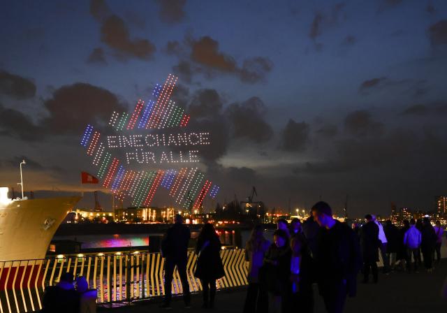 26 February 2026, Hamburg: Drones form the slogan "An opportunity for everyone" above the Elbe River at the Landungsbruecken during a show to launch the Hamburg Senate's Olympic campaign. Photo: Christian Charisius/dpa