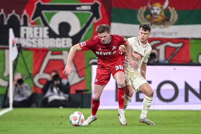 27 February 2026, Bavaria, Augsburg: Cologne's Marius Buelter and Augsburg's Robin Fellhauer battle for the ball during the German Bundesliga soccer match between FC Augsburg and 1. FC Cologne at the WWK Arena. Photo: Harry Langer/dpa - WICHTIGER HINWEIS: Gemäß den Vorgaben der DFL Deutsche Fußball Liga bzw. des DFB Deutscher Fußball-Bund ist es untersagt, in dem Stadion und/oder vom Spiel angefertigte Fotoaufnahmen in Form von Sequenzbildern und/oder videoähnlichen Fotostrecken zu verwerten bzw. verwerten zu lassen.