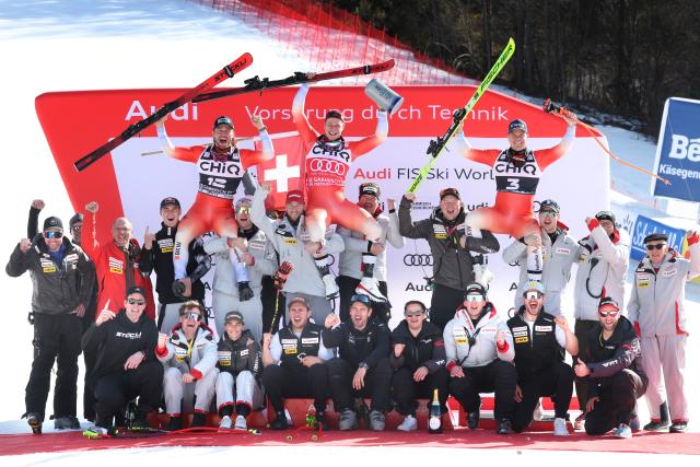 28 February 2026, Bavaria, Garmisch-Partenkirchen: (L-R) second-placed Alexis Monney, winner Marco Odermatt and third-placed Stefan Rogentin celebrate with their team at the award ceremony after the downhill competition of the Men's Alpine skiing World Cup, . Photo: Karl-Josef Hildenbrand/dpa