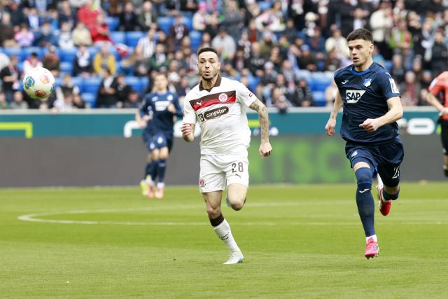 28 February 2026, Baden-Wuerttemberg, Sinsheim: St. Pauli's Mathias Pereira Lage (L) and Hoffenheim's Albian Hajdari battle for the ball during the German Bundesliga soccer match between TSG 1899 Hoffenheim and FC St. Pauli at PreZero Arena. Photo: Heiko Becker/dpa - WICHTIGER HINWEIS: Gemäß den Vorgaben der DFL Deutsche Fußball Liga bzw. des DFB Deutscher Fußball-Bund ist es untersagt, in dem Stadion und/oder vom Spiel angefertigte Fotoaufnahmen in Form von Sequenzbildern und/oder videoähnlichen Fotostrecken zu verwerten bzw. verwerten zu lassen.