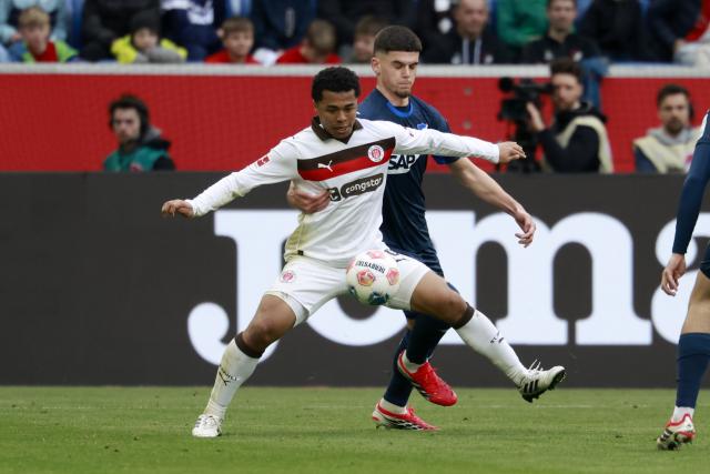 28 February 2026, Baden-Wuerttemberg, Sinsheim: St. Pauli's Joel Chima Fujita (L) in and Hoffenheim's Albian Hajdari battle for the ball during the German Bundesliga soccer match between TSG 1899 Hoffenheim and FC St. Pauli at PreZero Arena. Photo: Heiko Becker/dpa - WICHTIGER HINWEIS: Gemäß den Vorgaben der DFL Deutsche Fußball Liga bzw. des DFB Deutscher Fußball-Bund ist es untersagt, in dem Stadion und/oder vom Spiel angefertigte Fotoaufnahmen in Form von Sequenzbildern und/oder videoähnlichen Fotostrecken zu verwerten bzw. verwerten zu lassen.