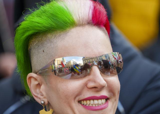 28 February 2026, Hesse, Frankfurt_Main: A participant in the rally wears her hair dyed in the colors of the Iran national flag. On social media, the Homgarayi Frankfurt group, among others, called for a "peaceful demonstration and march for freedom and democracy in Iran." Photo: Andreas Arnold/dpa