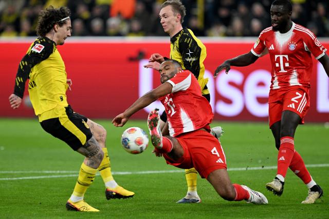28 February 2026, North Rhine-Westphalia, Dortmund: Bayern Munich's Jonathan Tah (C) and Borussia Dortmund's Fabio Silva (L) battle for the ball during the German Bundesliga soccer match between Borussia Dortmund and FC Bayern Munich at Signal Iduna Park. Photo: Federico Gambarini/dpa - IMPORTANT NOTICE: DFL and DFB regulations prohibit any use of photographs as image sequences and/or quasi-video.