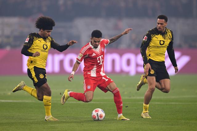 28 February 2026, North Rhine-Westphalia, Dortmund: Bayern Munich's Luis Diaz (C) and Borussia Dortmund's Karim Adeyemi and Borussia Dortmund's Felix Nmecha battle for the ball during the German Bundesliga soccer match between Borussia Dortmund and FC Bayern Munich at Signal Iduna Park. Photo: David Inderlied/dpa - IMPORTANT NOTICE: DFL and DFB regulations prohibit any use of photographs as image sequences and/or quasi-video.
