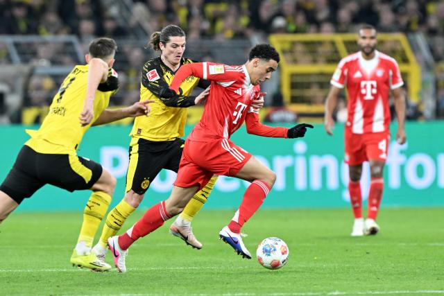 28 February 2026, North Rhine-Westphalia, Dortmund: Bayern Munich's Jamal Musiala (R) and Borussia Dortmund's Marcel Sabitzer battle for the ball during the German Bundesliga soccer match between Borussia Dortmund and FC Bayern Munich at Signal Iduna Park. Photo: Federico Gambarini/dpa - IMPORTANT NOTICE: DFL and DFB regulations prohibit any use of photographs as image sequences and/or quasi-video.